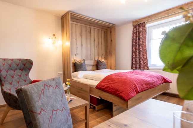 Bett in der Familiensuite des Hotel Post Örglwirt in Mariapfarr