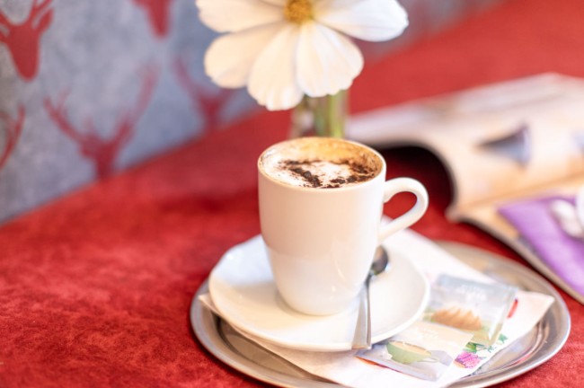 Kaffee und Blumendekoration auf dem Zimmer