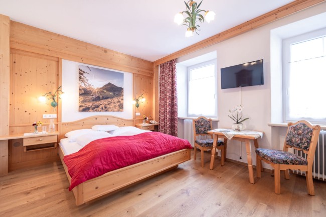 Doppelzimmer mit Tisch und Stühle und TV im Typ Almrausch