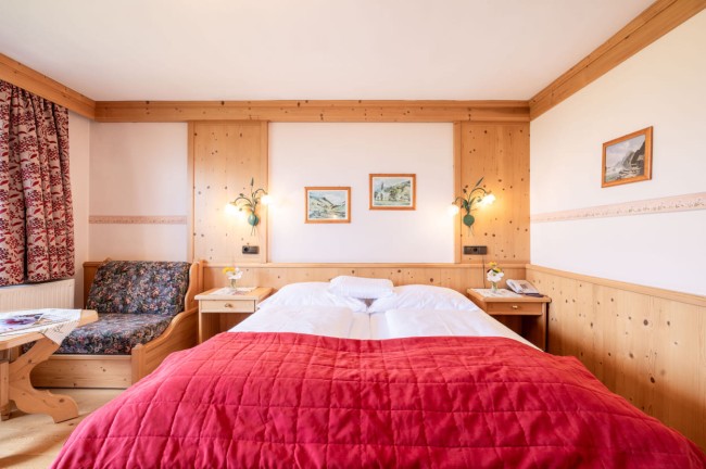 Doppelbett und Sitzecke im Hotel Post Örglwirt